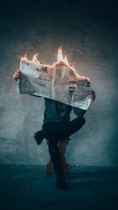 Person with burning newspaper
